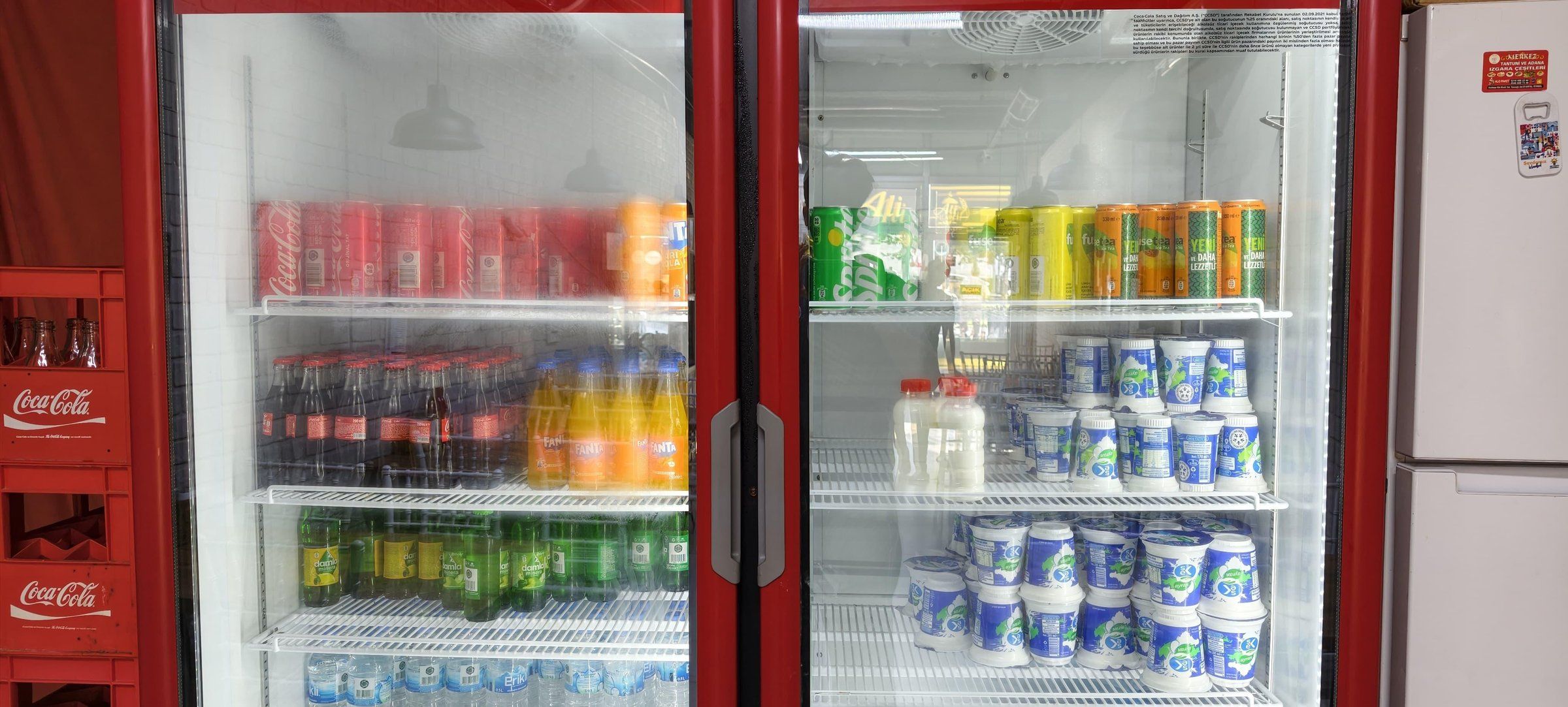 Soğutucu dolapta raf raf dizilmiş ayran, soda, şalgam ve su şişeleri